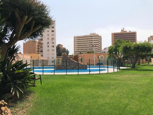 a park with a fence and grass and buildings at Apartamento Exclusivo Frente al Mar in Aguadulce