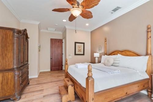 a bedroom with a wooden bed and a ceiling fan at Serene Golf Course Retreat with Pool & Spa Game Room in Indio