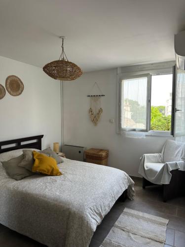 une chambre avec un lit, une chaise et des fenêtres dans l'établissement Appartement lumineux avec parking privé et balcon, à Toulon