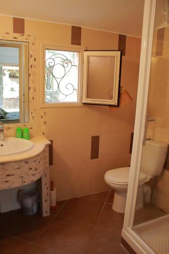 une salle de bain avec toilettes, lavabo et fenêtre dans l'établissement Chambres d'hôtes Le Clos des Oliviers, à Sorbo-Ocagnano