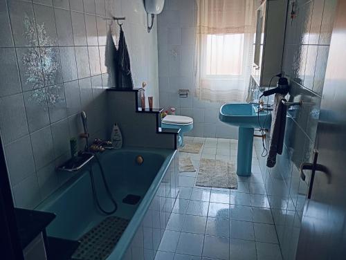 Un baño con bañera, lavabo e inodoro. en Villa Marissimo, en Realmonte