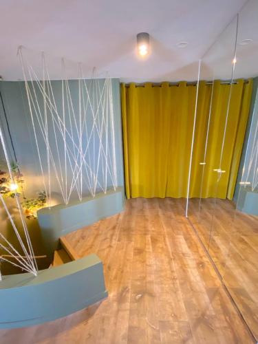 une pièce avec un rideau jaune et un parquet dans l'établissement Le Penthouse Eiffel, à Paris