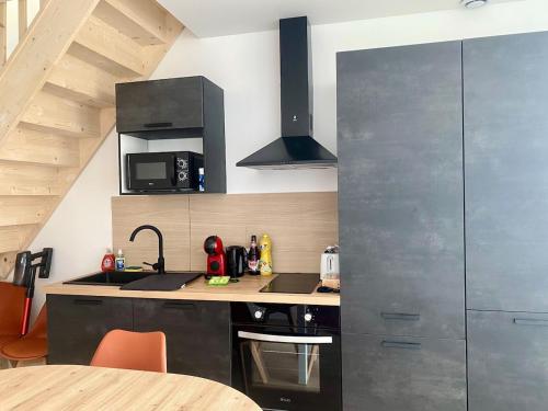a kitchen with a sink and a stove top oven at Duplex cosy - à 100 m de la gare - lumineux & confortable in Châtellerault