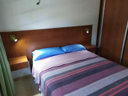 a bedroom with a bed with blue pillows on it at Departamentos Ojos del Alma in Valeria del Mar