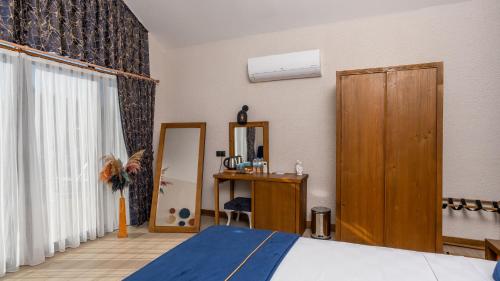 a bedroom with a bed and a closet and a mirror at Vista Del Amor Faralya in Fethiye