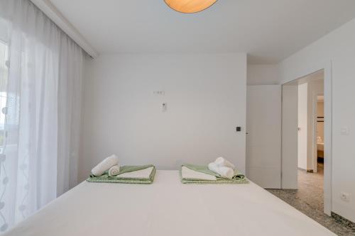 a bedroom with white walls and a bed with two phones at DeLuxe Seaview Apartment KENNEDY I in Mimice