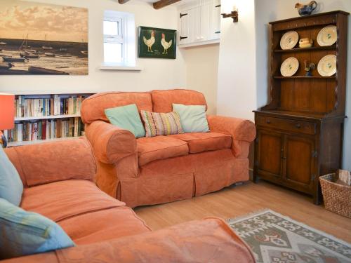 a living room with a couch and a chair at Pump Cottage in Brancaster