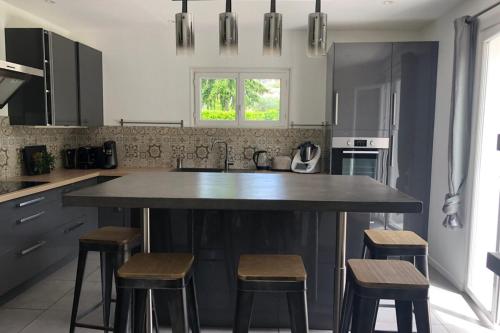 une cuisine avec un grand îlot et des tabourets dans l'établissement Beautiful and spacious villa - swimming pool - garden, à Le Rouret