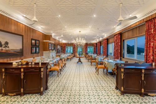 a restaurant with tables and chairs and a chandelier at Mayfair Manor Jungpana in Darjeeling
