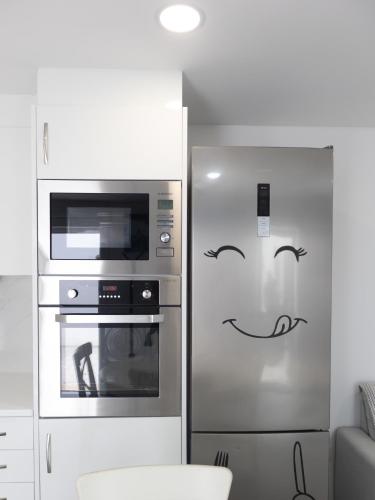 a refrigerator with a smiley face drawn on it in a kitchen at Casa de Praia Daniel 2 in Lavra