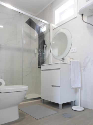 a white bathroom with a toilet and a shower at Casa de Praia Daniel 2 in Lavra