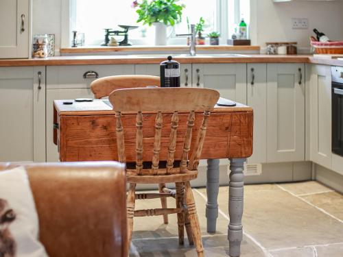 a kitchen with a wooden table and two chairs at Little Badger Cottage in Kirkburton