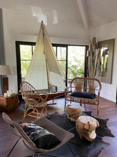 un salon avec des chaises et un bateau au sol dans l'établissement Villa au cœur du Cap Ferret, à Lège-Cap-Ferret