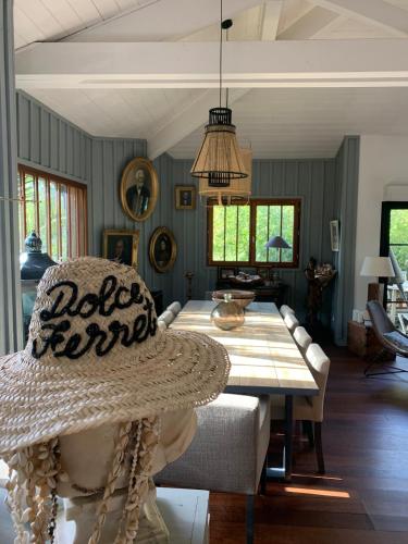 - une salle à manger avec une table et un chapeau dans l'établissement Villa au cœur du Cap Ferret, à Lège-Cap-Ferret