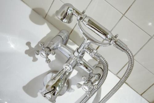 - une pomme de douche en chrome dans la salle de bains dans l'établissement Paris Marais Design residence, à Paris