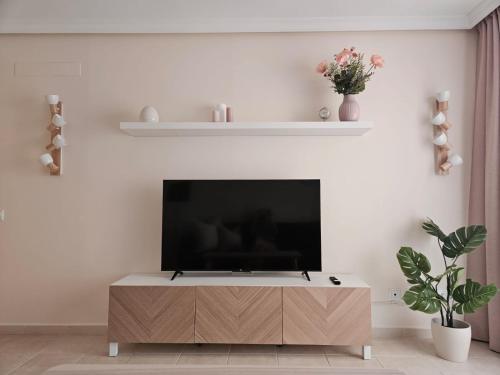a living room with a flat screen tv on a cabinet at Summer breeze in Puerto de Santiago