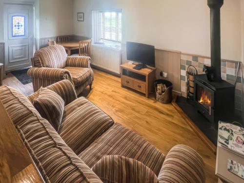 a living room with two couches and a fireplace at Little Netherleigh in Trearddur