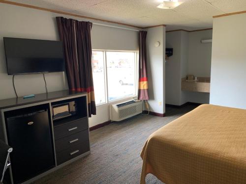 a hotel room with a bed and a television at Pigeon Forge Parkway Inn in Pigeon Forge