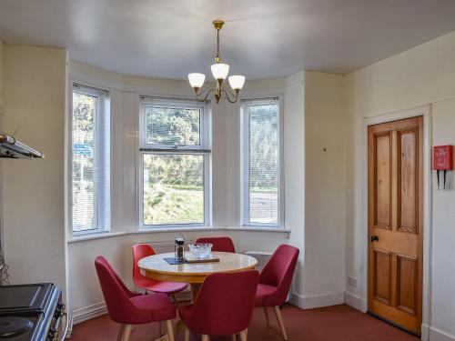IanstownにあるStrathlene Lodgeのダイニングルーム(テーブル、赤い椅子付)