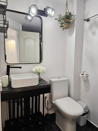 a bathroom with a toilet and a sink and a mirror at Casa Eladi in Eforie Sud