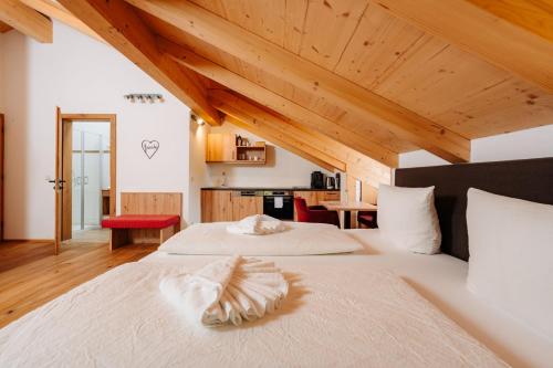 two beds in a room with wooden ceilings at Landhotel Berger in Ainring