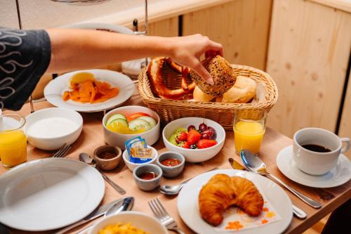 a table with a basket of food and a person eating bread at Landhotel Berger in Ainring
