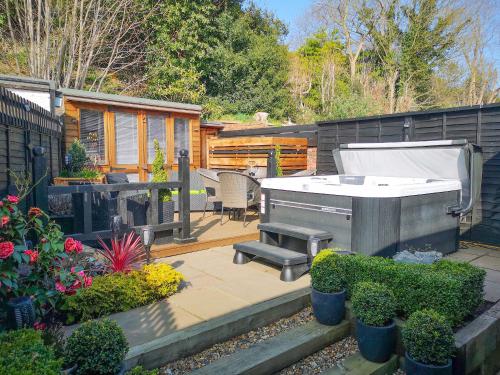 une arrière-cour avec un bain à remous et un grill dans l'établissement Riverside Cottage, à Reedham