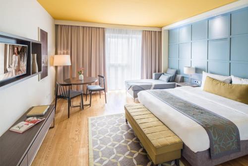 a hotel room with a large bed and a table at Citadines City Centre Frankfurt in Frankfurt/Main