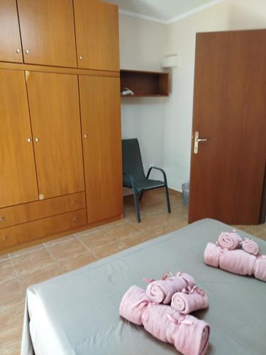 two pink towels on a bed in a room at THANground floor in Nea Kalikratia