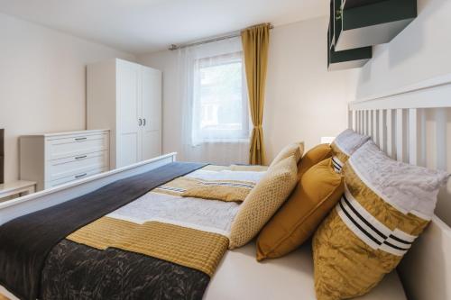 a bedroom with a large bed with pillows at Karavanke Holiday Getaway in Hrušica