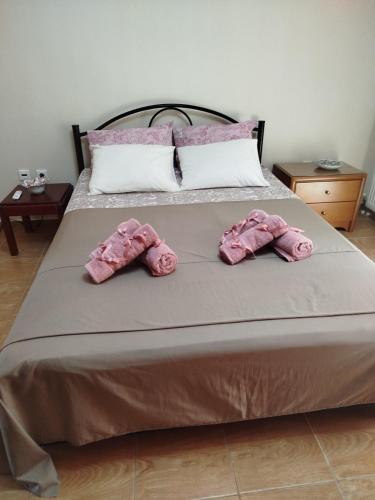 a bed with two pink mitts on it at THANground floor in Nea Kalikratia