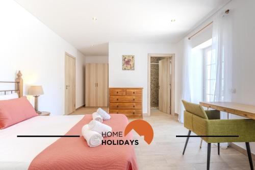 a bedroom with a bed and a table and a desk at #331 Casa Chico Rita by Home Holidays in Sesmarias