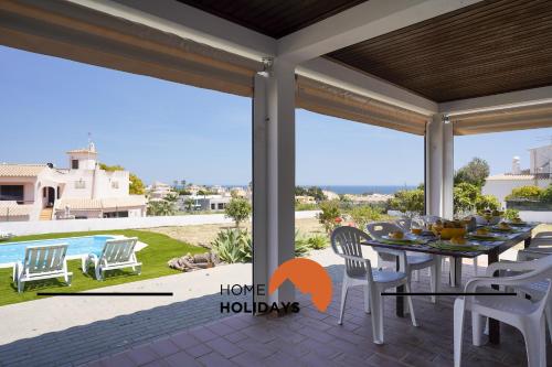 a dining room with a table and chairs on a patio at #331 Casa Chico Rita by Home Holidays in Sesmarias