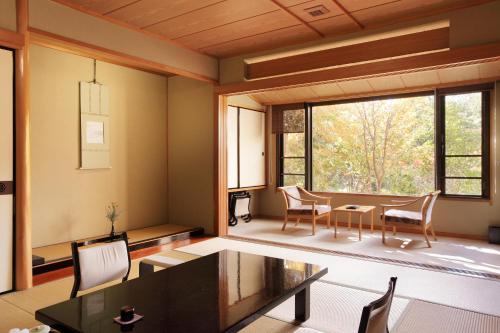 a living room with a table and chairs and a large window at Senkyo in Numata