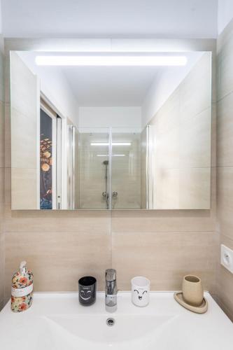 une salle de bain avec un lavabo et un miroir dans l'établissement Villa Oia 300 m from the beach, à Conca