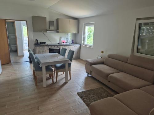 a living room with a couch and a table at Apartmani Dalmatinka in Metajna