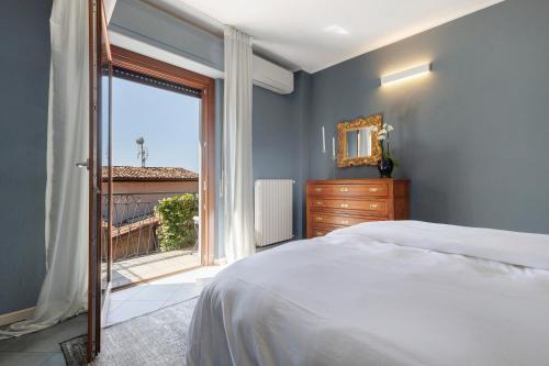 une chambre avec un lit et une grande fenêtre dans l'établissement Appartamento Il Campanile, à Tignale