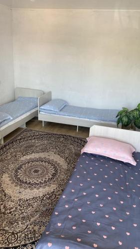 a room with two beds and a rug at Pari Guest House in Kaji-Say