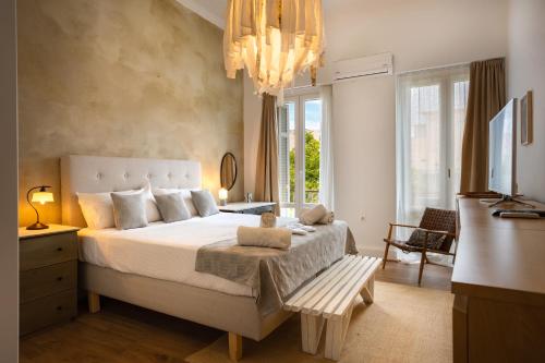 a bedroom with a large bed and a chandelier at Dimora - A Spacious Luxury Penthouse in Town's Heart in Corfu Town
