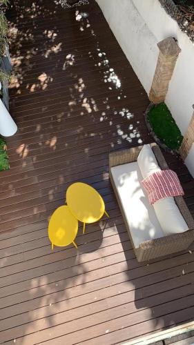 une table et des chaises jaunes sur une terrasse en bois dans l'établissement Appartement T2 avec grande terrasse idéalement situé Cannes centre, à Cannes
