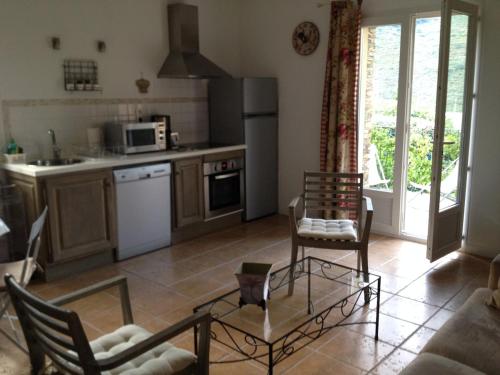 une cuisine avec une table et des chaises dans une pièce dans l'établissement Maison independante en pierre du pays, Jardin,Clim,Wifi,Tnt a 5 mn de la Mer Mausoleo, à Brando