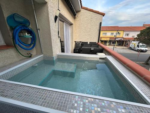 une piscine sur le côté d'un immeuble dans l'établissement Évasion au bord de mer, Appartement avec piscine, au Barcarès