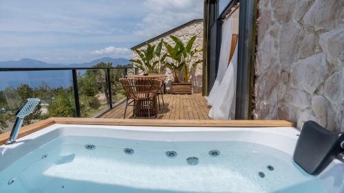 a jacuzzi tub on a balcony with a table at Vista Del Amor Faralya in Fethiye