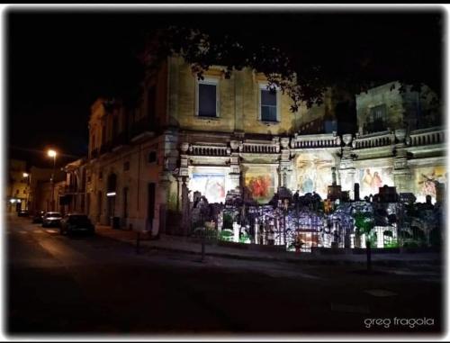 a building with lights on the side of it at night at ACasaMia in Manduria