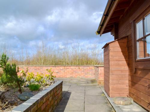 a brick retaining wall next to a house at Fern Lodge - Uk13321 in Melbourne