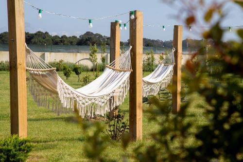two hammocks hanging from poles in a garden at Guest House MJ in Póvoa de Varzim