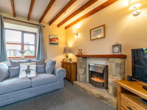 a living room with a couch and a fireplace at Maybeck Cottage in Whitby
