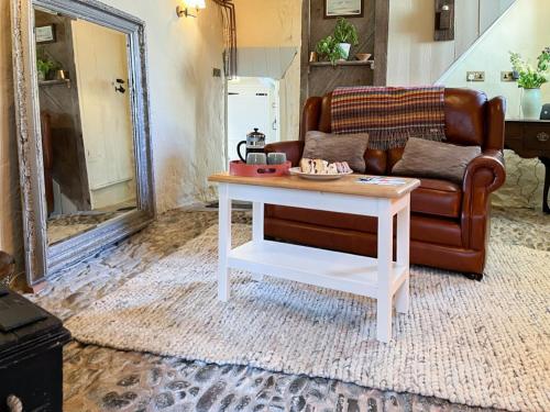 a living room with a couch and a coffee table at Cobble Cottage in Instow