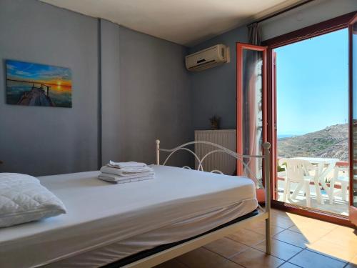a bedroom with a bed and a balcony with a view at Balcony of vari in Vári