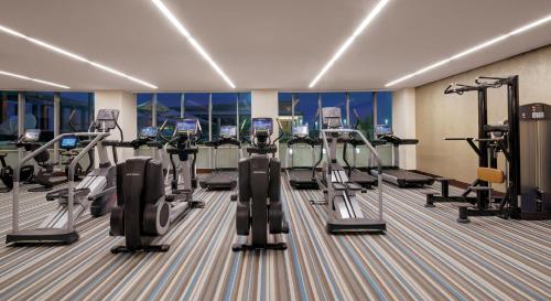 a gym with many treadmills and cardio machines at Kempinski Hotel Gold Coast City in Accra